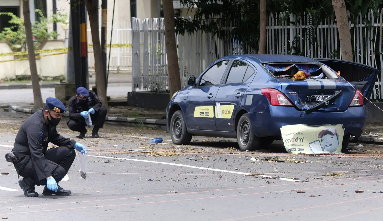 Polisi mengumpulkan bukti dari sekitar lokasi serangan bom di Gereja Katedral Makassar, Senin (29/3/2021). Dua penyerang yang diyakini merupakan anggota jaringan militan yang setia kepada ISIS meledakkan diri di luar Gereja Katedral Makassar di tengah Misa Minggu Palma. (AP/Masyudi S. Firmansyah)