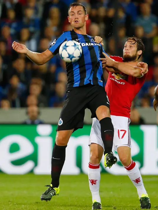  Bek MU, Daley Blind (kanan) berebut bola dengan penyerang Club Brugge Tom De Sutter saat pertandingan Play – Off Liga Champion di Stadion Jan Breydel, Belgia, Rabu (26/8/2015). Gol MU dicetak oleh Wayney Rooney dan Ander Herrera. (Reuters/Yves Herman)
