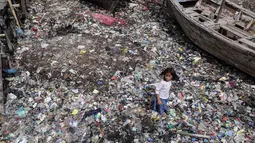 Seorang anak tengah berlari di tumpukan sampah yang mengering di dermaga Tempat Pelelangan Ikan Cilincing, Jakarta Utara, Rabu (8/2). (Fery Pradolo/Liputan6.com)