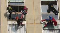 Sejumlah orang berpakaian superhero turun dari atap untuk memberi kejutan di jendela kamar pasien anak di bangsal Pediatri rumah sakit San Paolo di Milan, Italia, Rabu (15/12/2021). Aksi Spiderman dkk itu untuk menghibur anak-anak yang dirawat di rumah sakit tersebut. (AP Photo/Luca Bruno)