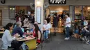 Orang-orang menikmati makanan di kafe di Abima Square di kota Tel Aviv, Israel (20/5/2021). Israel dan dua kelompok bersenjata utama Palestina di Gaza, Hamas dan Jihad Islam, menyetujui gencatan senjata untuk mengakhiri konflik selama 11 hari. (AFP/Gideon Markowicz)