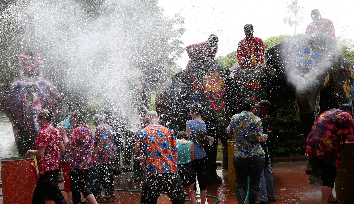 Sejumlah gajah menyemprotkan air kepada wisatawan saat perayaan tahun baru kuno Thailand atau Songkran di provinsi Ayutthaya, Thailand (11/4). Perayaan ini digelar selama tiga hari, dimulai pada 13 April. (AP Photo/Sakchai Lalit)