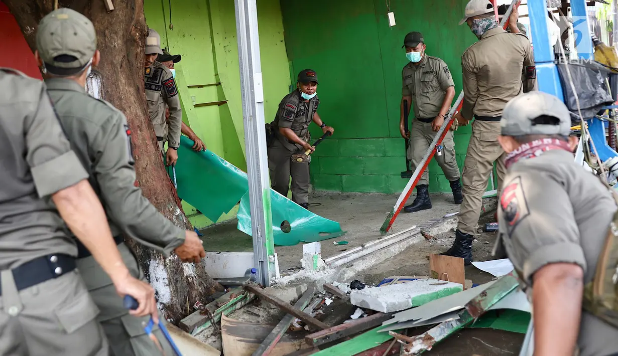 Petugas Satpol PP membongkar bangunan semi permanen di Jalan Nusantara Raya, Depok, Jawa Barat, Rabu (18/4). Pembongkaran dilakukan untuk menertibakan bangunan liar yang berdiri di sepanjang trotoar. (Liputan6.com/Immanuel Antonius)