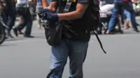 Terlihat seorang pria membawa senjata di Jalan Thamrin, Jakarta, Kamis (14/1). Dari foto, terlihat seorang pria berkaos hitam, topi hitam dan memakai sarung tangan tengah memegang senjata api. (REUTERS/Veri Sanovri/Xinhua)