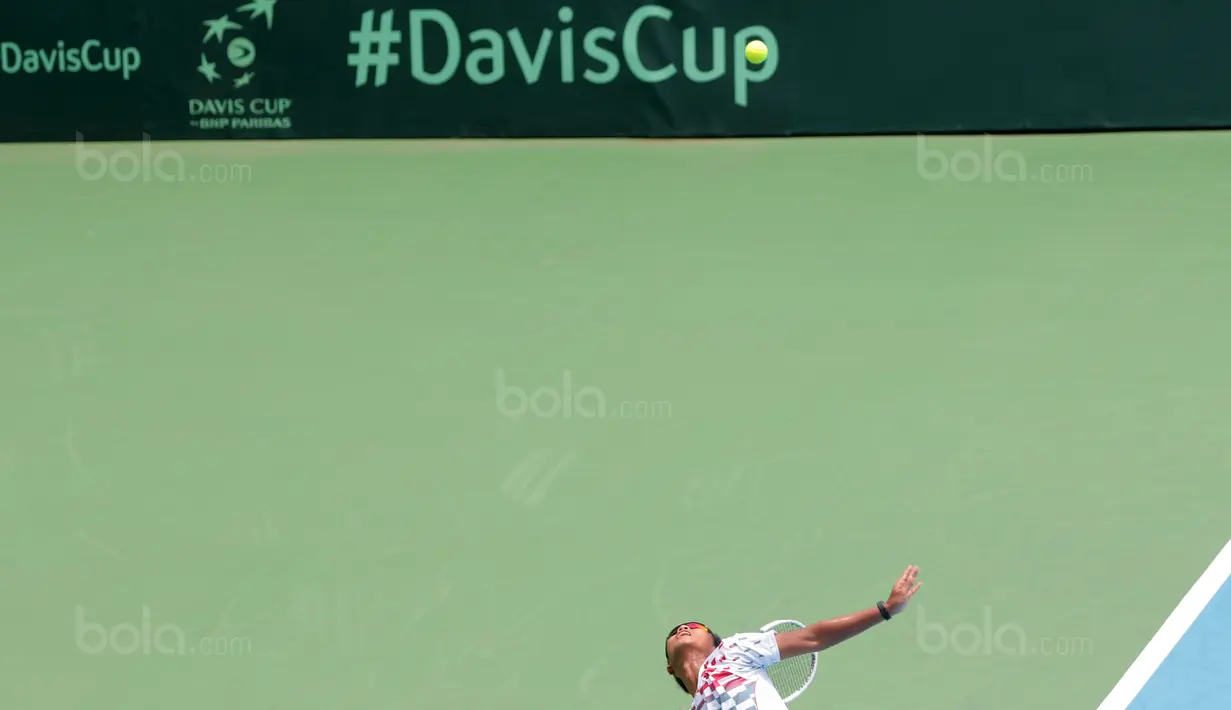 Petenis Indonesia, Althaf Dhaifullah melakukan servis saat melawan petenis Fiipina Davis 2018 grup dua Asia/Oceania di Senayan, Jakarta, Sabtu (3/2/2018). Althaf kalah 3-6, 2-6. (Bola.com/Nick Hanoatubun)