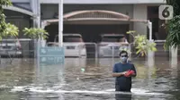 Warga melintasi banjir rob yang merendam Kompleks Perumahan Pantai Mutiara, Pluit, Jakarta, Minggu (7/6/2020). (merdeka.com/Iqbal S. Nugroho)
