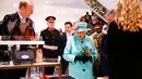 Ratu Elizabeth II melihat-lihat etalase tas di department store Fenwick saat mengunjungi pusat perbelanjaan Lexicon di Bracknell, London, Jumat (19/10). Ratu Elizabeth berjalan mengamati aksesoris sambil memegang buket bunga. (AP Photo Pool)