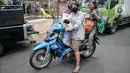 Warga menggunakan sepeda motor untuk mengangkut bahan pangan yang dibeli dari Program Pangan Bersubsidi di RPTRA Permata Intan, Bidara Cina, Jakarta Timur, Rabu (9/2/2022). (merdeka.com/Iqbal S Nugroho)
