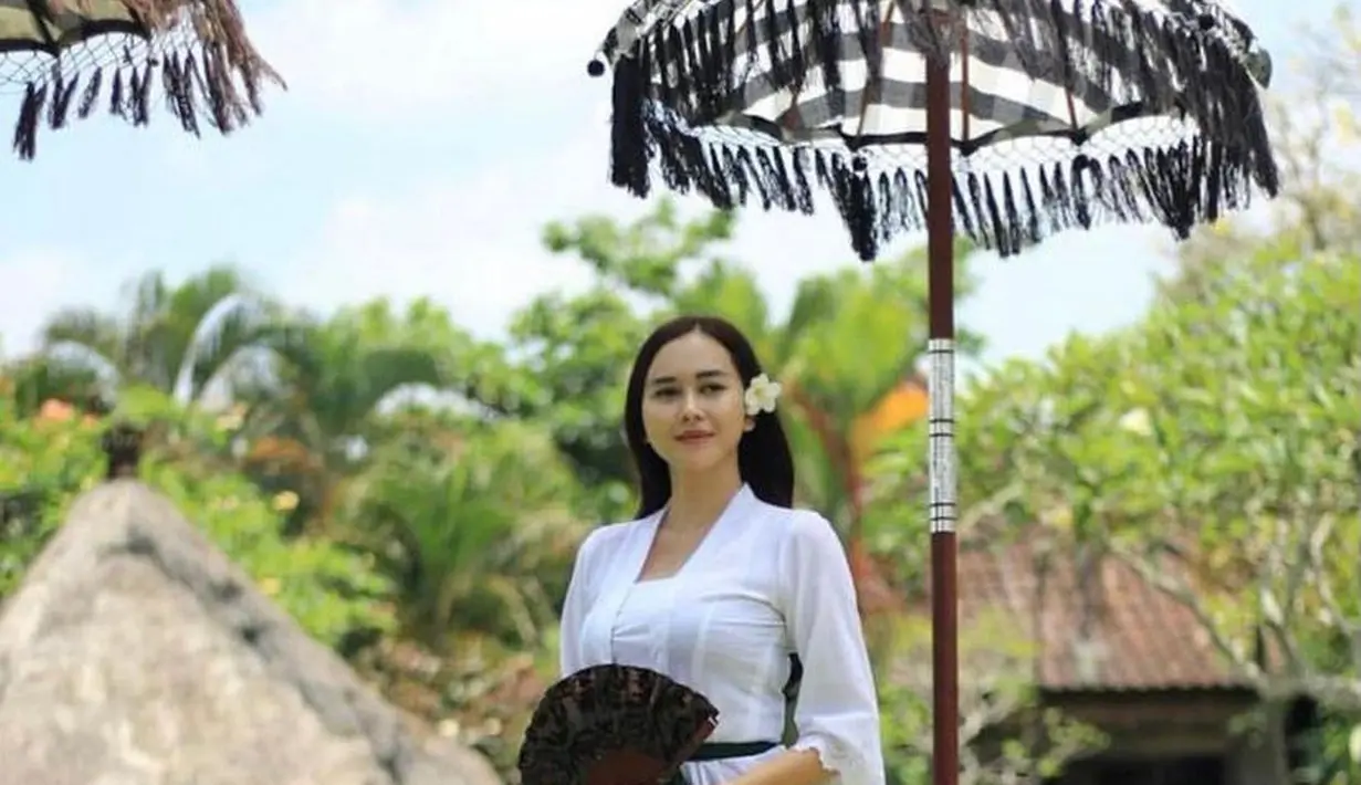 Kamu yang senang simple, boleh tiru gaya Aura Kasih ini. Kebaya katun putih disambung batik cokelat dan sabuk hijau, terasa santai & nyaman dipandang. (Instagram/aurakasih).