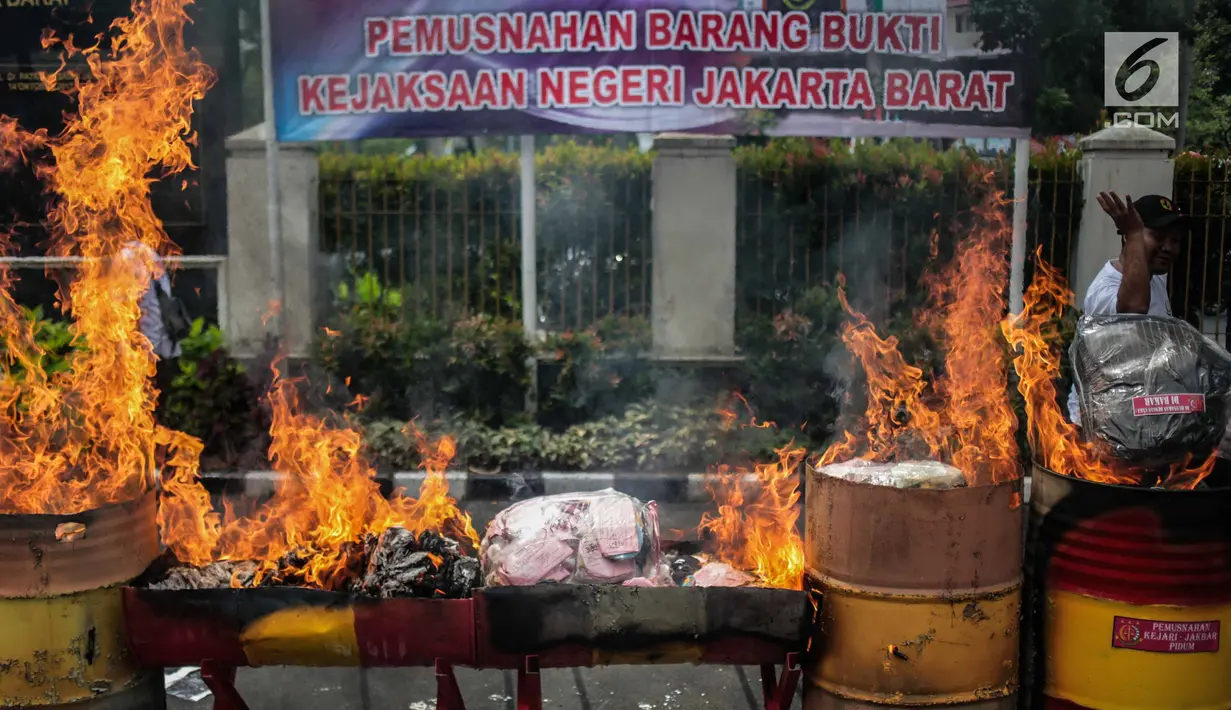 Petugas membakar barang bukti tindak pidana umum di lapangan Kejaksaan Negeri Jakarta Barat, Selasa (11/12). Barang bukti yang dimusnahkan berupa senjata Api, psikotropika, makanan, obat-obatan dan kosmetika. (Liputan6.com/Faizal Fanani)