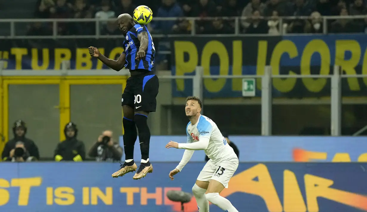 Penyerang Inter Milan, Romelu Lukaku melompat untuk mendapatkan bola dari kawalan pemain Napoli, Amir Rrahmani  pada pertandingan lanjutan Liga Serie A Italia di stadion San Siro di Milan, Italia, Kamis (5/1/2023). Inter Milan menang tipis atas Napoli dengan skor 1-0. (AP Photo/Luca Bruno)