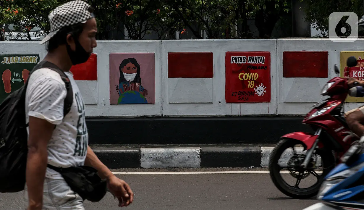 Warga melintasi mural sosialisasi bahaya COVID-19 di Jalan Sultan Iskandar Muda, Jakarta, Rabu (23/9/2020). PSBB pengetatan sepekan terakhir ini belum efektif menurunkan angka jumlah harian Covid-19 di DKI yang tercatat bertambah 1.122 kasus di ibu kota pada Selasa (22/9). (Liputan6.com/Johan Tallo)