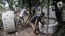 Pekerja menyelesaikan pembangunan sumur resapan di RPTRA Meruya Utara, Jakarta, Selasa (25/1/2022). Pembangunan 100 titik sumur resapan ini bertujuan untuk mengantisipasi banjir yang kerap terjadi di wilayah tersebut. (merdeka.com/Iqbal S. Nugroho)