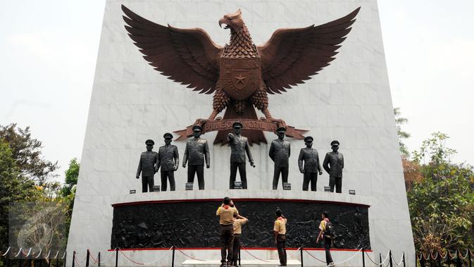 Sejumlah Pramuka mengabadikan patung tujuh pahlawan revolusi di Monumen Pancasila Sakti, Jakarta, Selasa (29/9/2015). Pemerintah akan mengadakan upacara peringatan Hari Kesaktian Pancasila pada 1 Oktober mendatang. (Liputan6.com/Helmi Fithriansyah)