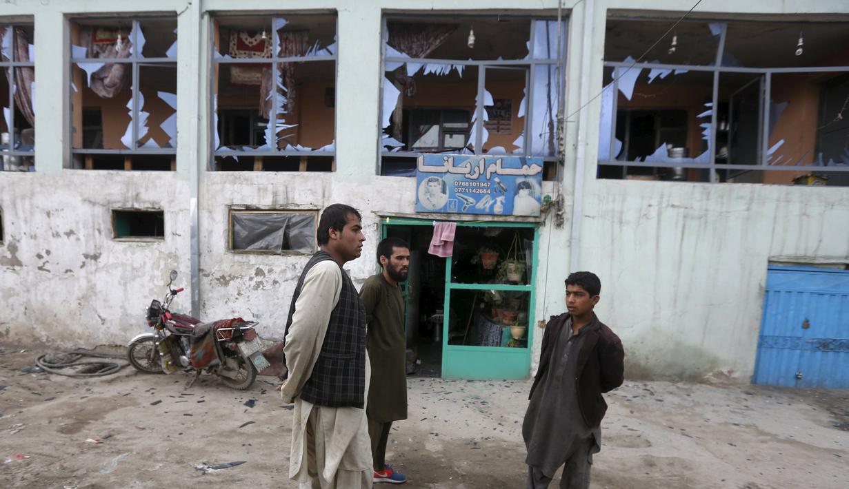 Pemilik toko mengamati jendela yang pecah akibat ledakan bom bunuh diri ledakan di Kabul, Afghanistan, Selasa (19/4). Suara ledakan terdengar dan mengguncang kaca jendela hingga radius beberapa mil. (REUTERS/Omar Sobhani)