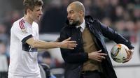 Aksi Pelatih Bayern Munchen, Josep Guardiola (kanan) saat memberi instruksi ke Thomas Mueller, saat pertandingan lanjutan Bundesliga kontra Hannover, di HDI Arena, Sabtu (19/12/2015) malam. Guardiola hampir dipastikan meninggalkan Bayern Munchen pada akhi