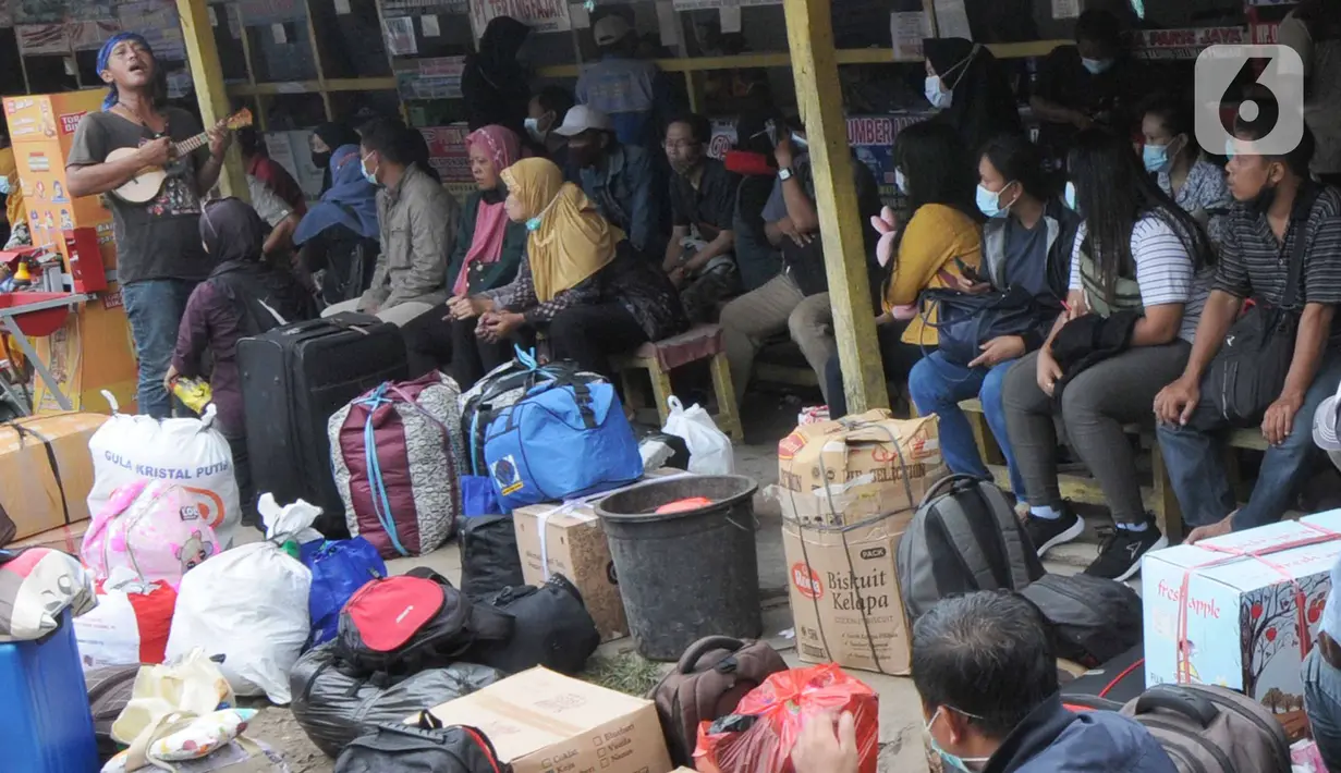 Seniman mengamen di antara pemudik yang memadati terminal bayangan di Pasar Jumat, Jakarta, Rabu (5/5/2021). Jelang pemberlakuan larangan mudik 2021 pada esok hari, sejumlah terminal bayangan di wilayah Jabodetabek dipadati para pemudik tujuan Pulau Jawa dan Sumatera. (merdeka.com/Arie Basuki)
