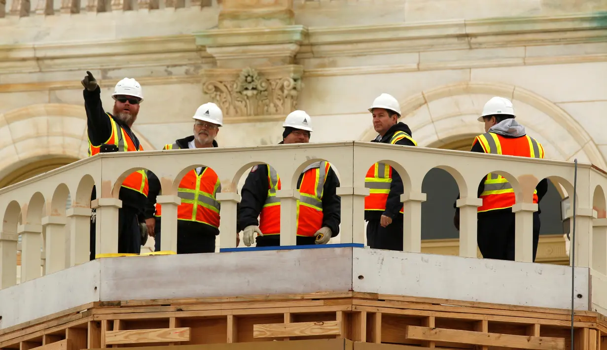 Pekerja konstruksi melihat keadaan sekitar dari balkon U.S. Capitol, Washington, Kamis (8/12). Rencananya di U.S. Capitol akan digelar acara pelantikan Presiden terpilih Donald Trump. (REUTERS/Jonathan Ernst)