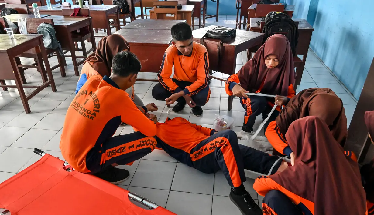 Siswa dilatih untuk tetap tenang ketika terjadi bencana. (CHAIDEER MAHYUDDIN/AFP)