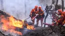 Petugas pemadam kebakaran berusaha memedamkan kebakaran hutan di Xichang, Provinsi Sichuan, China, Selasa (31/3/2020). Kebakaran hutan menewaskan 18 anggota pemadam kebakaran dan seorang buruh tani hutan setempat yang bertugas sebagai penunjuk jalan bagi anggota pemadam kebakaran tersebut. (STR/AFP)