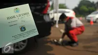 Kertas hasil uji emisi kendaraan diperlihatkan di pintu satu Gelora Bung Karno, Jakarta, Selasa (17/5). Pemkot Administrasi Jakpus melakukan uji emisi kendaraan selama tiga hari untuk mengevaluasi kualitas udara perkotaan. (Liputan6.com/Gempur M Surya)