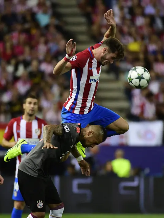 Saul Niguez (atas) menhalau bola dari kejaran pemain Bayern Munich, Arturo Vidal pada laga grup D Liga Champions di Vicente Calderon stadium, Madrid, Kamis (29/9/2016) dini hari WIB. (AFP/Pierre-Philippe Marcou)