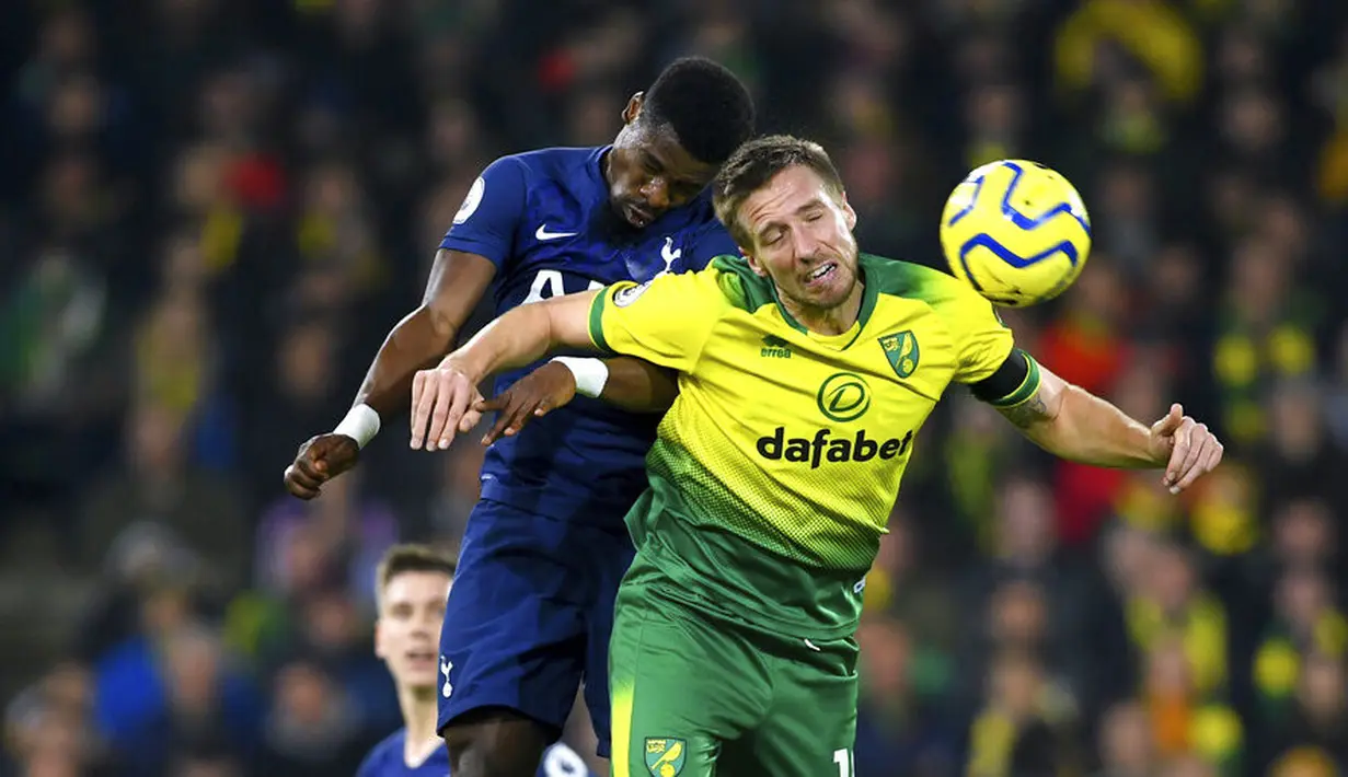 Pemain Tottenham Hotspur, Serge Aurier, berebut bola dengan pemain Norwich City, Marco Stiepermann, pada laga Premier League 2019 di Stadion Carrow Road, Sabtu (28/12). Kedua tim bermain imbang 2-2. (AP/Joe Giddens)