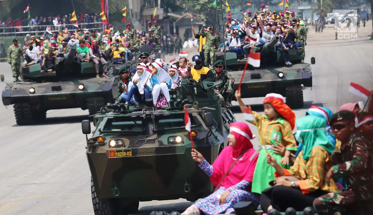 Masyarakat ikut menaiki tank saat menonton atraksi militer TNI dalam geladi resik HUT TNI ke-72 di Cilegon, Banten, Selasa (3/10). Geladi resik tersebut untuk memperingati HUT TNI ke-72 yang dilaksanakan tanggal 5 Oktober. (Liputan6.com/Angga Yuniar)