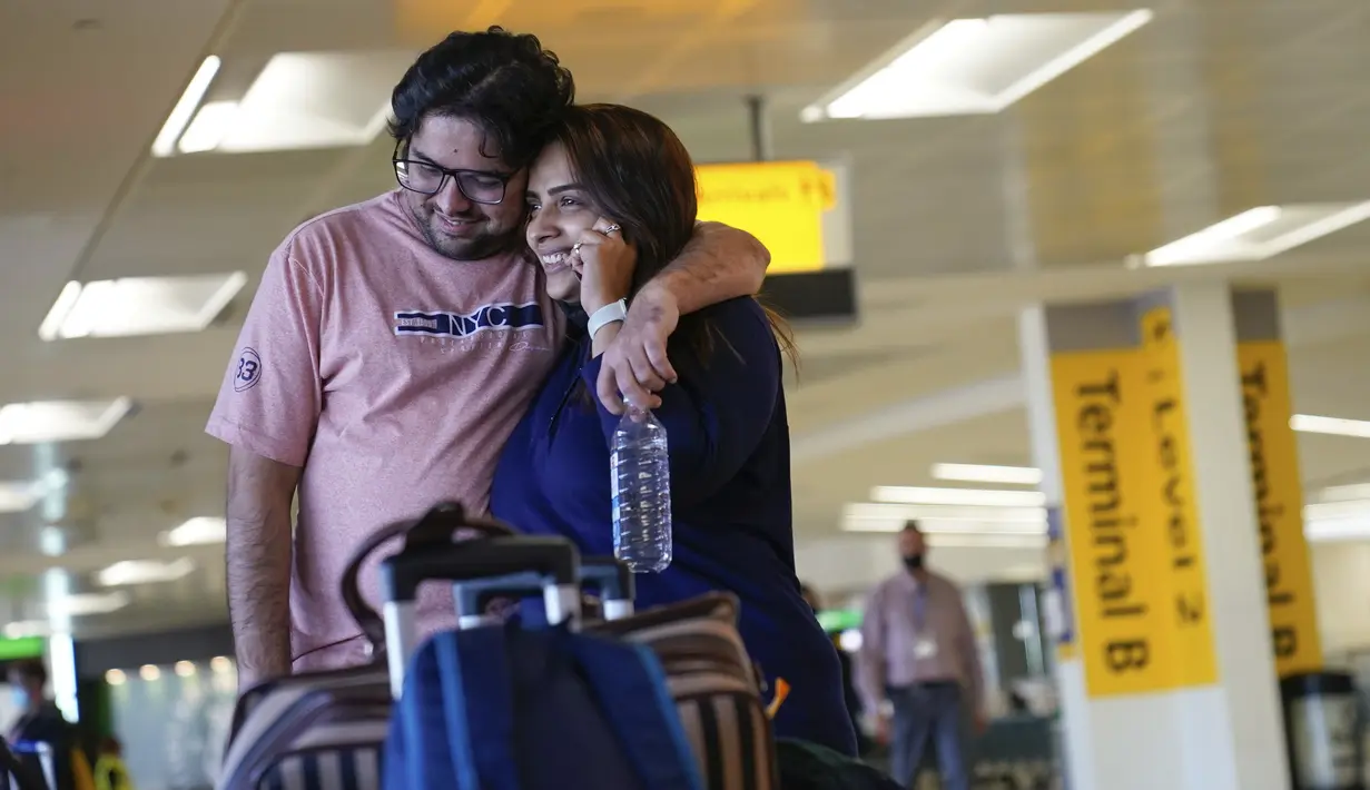 Jolly Dave menelepon setelah tiba dari India dan bertemu kembali dengan pacarnya, Nirmit Shelat, di Bandara Internasional Newark Liberty, New Jersey, Senin (8/11/2021). AS membuka kembali perbatasannya untuk pengunjung asing, mengakhiri larangan masuk selama 20 bulan. (AP Photo/Seth Wenig)