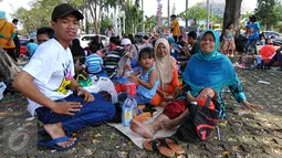 Berwisata bersama keluarga memang menjadi pilihan menarik berkunjung ke TMII, Jakarta, Minggu (19/07/2015). Makan bersama sambil menggelar tiker di tempat wisata menjadi pilihan warga yang mengunjungi tempat wisata TMII. (Liputan6.com/Yoppy Renato)