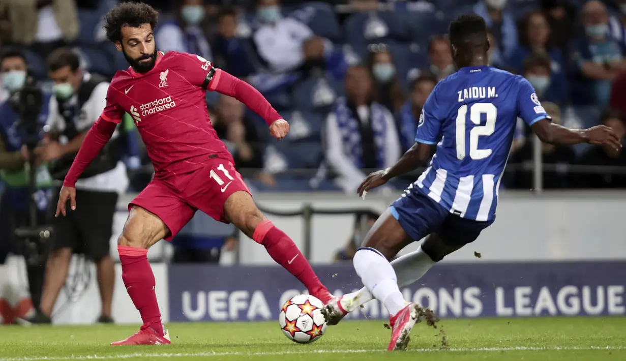Penyerang Liverpool, Mohamed Salah berusaha melewati pemain Porto, Zaidu Sanusi pada pertandingan grup B Liga Champions di stadion Dragao di Porto, Portugal, Rabu (29/9/2021). (Dengan hasil ini, Liverpool masih berada di puncak klasemen dengan 6 poin. (AP Photo/Luis) Vieira)