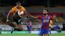 Gelandang Wolverhampton Wanderers, Adama Traore, berebut bola dengan gelandang Crystal Palace, Andros Townsend, pada laga lanjutan Premier League di Molineux Stadium, Selasa (21/7/2020) dini hari WIB. Wolves menang 2-0 atas Crystal Palace. (AFP/Martin Rickett/pool)