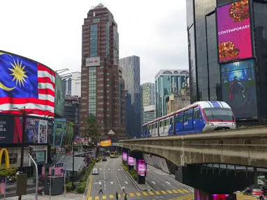 Sebuah LRT (Light Rain Transit) melewati papan bendera Nasional di Kuala Lumpur, Malaysia, Selasa (14/9/2021). Malaysia pecah rekor tembus dua juta kasus Covid-19 dengan tambahan 15.669 kasus Selasa (14/9/2021). (AP Photo/Vincent Thian)