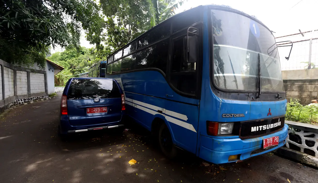Kondisi bus dan mobil dinas yang terparkir di area belakang Gedung DPR/MPR, Jakarta, Selasa (5/12). Mobil-mobil berplat merah tersebut dibiarkan mangkrak hingga berkarat lantaran menunggu proses lelang. (Liputan6.com/Johan Tallo)