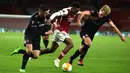 Gelandang Arsenal, Joe Willock, berusaha melewati dua pemain Dundalk pada laga lanjutan Liga Europa 2020/2021 di Emirates Stadium, Jumat (30/10/2020) dini hari WIB. Arsenal menang 3-0 atas Dundalk. (AFP/Glyn Kirk)