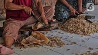 Sejumlah pekerja memotong kulit sapi di rumah produksi kerupuk kulit rumahan di Katulampa, Bogor, Jawa Barat, Sabtu (17/9/2022). Menko bidang Perekonomian, Airlangga Hartarto mengatakan, urgensi peran UMKM menjadi perhatian utama pemerintah untuk dapat memberikan dukungan bagi pelaku usaha. Salah satunya melalui akses pembiayaan KUR yang besar. (Liputan6.com/Angga Yuniar)