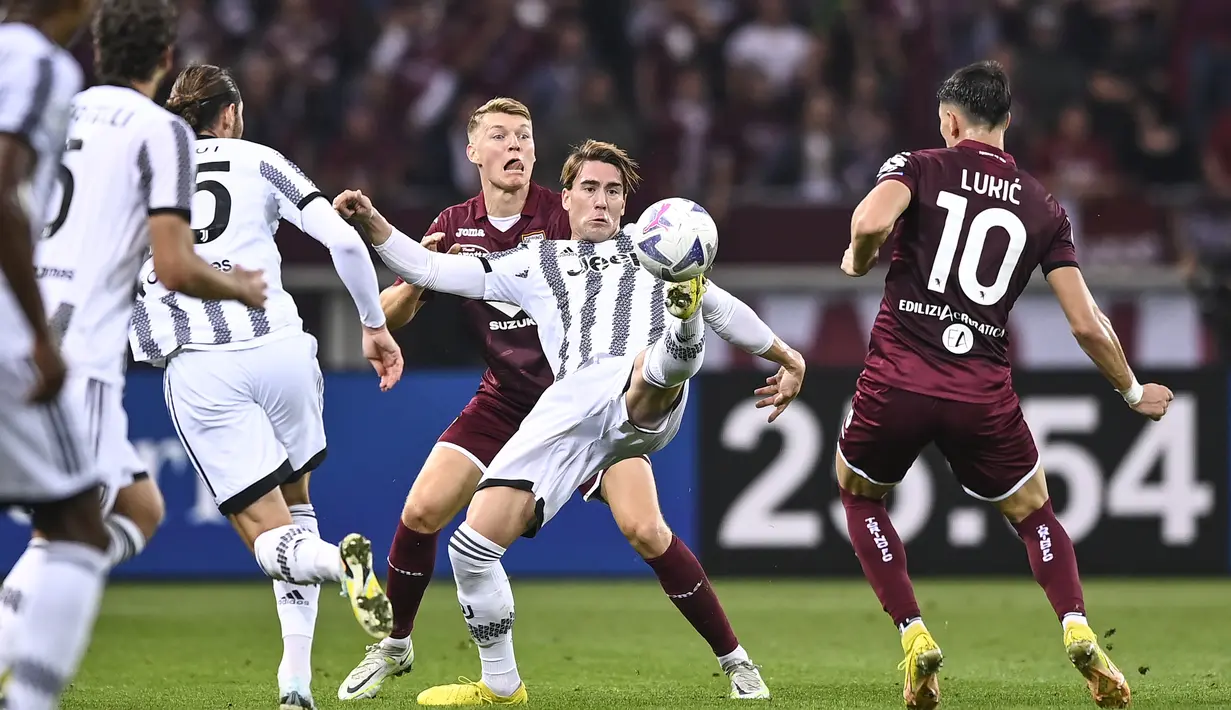 Penyerang Juventus, Dusan Vlahovic berusaha mengontrol bola dari kawalan pemain Torino, Sasa Lukic pada pertandingan lanjutan Liga Serie A Italia di di Stadio Olimpico Grande Torino di Turin, Italia, Sabtu (15/10/2022). Torino kini tertahan di posisi 11 dengan selisih lima poin dari rival sekotanya.  (Fabio Ferrari/LaPresse via AP)
