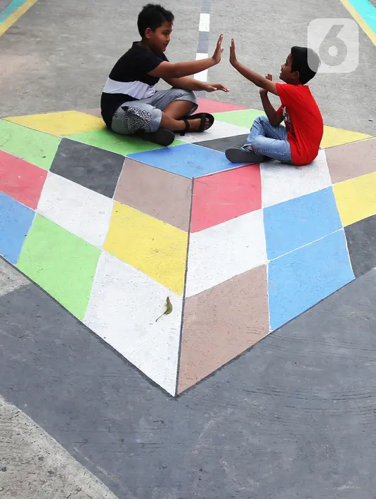 Anak-anak bermain di atas lukisan tiga dimensi (3D) di Jalan Perumahan Bojong Depok Baru 1, RT 03/RW 19 Bojonggede, Bogor, Jawa Barat, Selasa (3/8/2020). Dalam rangka menyambut HUT ke-75 RI, warga berbenah memperindah lingkungan dengan melukis 3D pada jalan. (merdeka.com/Arie Basuki)