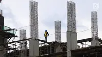 Seorang pekerja berjalan di atas bangunan gedung yang dalam tahap penyelesaian di Jakarta, Jumat (26/1). Jumlah tenaga kerja konstruksi yang tersertifikasi saat ini di bawah 10% atau hanya 720.000 dari 8,10 juta tenaga kerja. (Liputan6.com/Angga Yuniar)