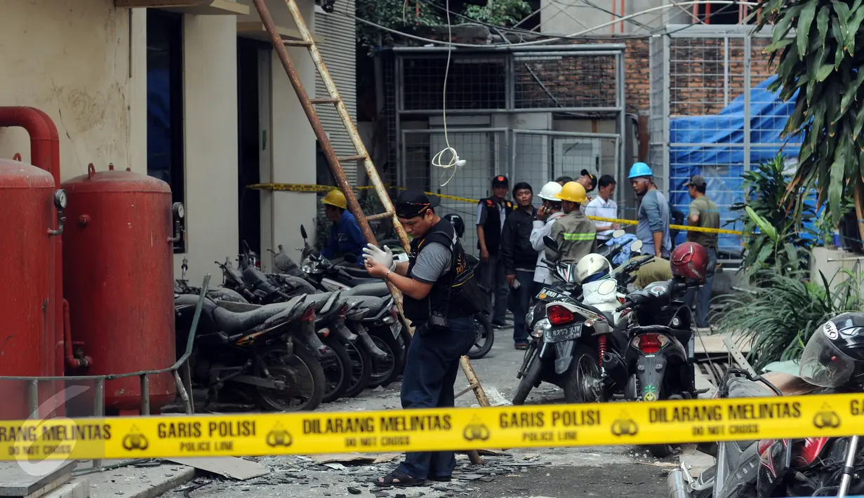 Petugas kepolisian melakukan olah tempat kejadian perkara jatuhnya material dari pembangunan gedung Kemenhan di depan gedung Ortala Kemenkopolhukam, Jakarta, Senin (30/11/2015).(Liputan6.com/Helmi Fithriansyah)
