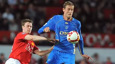 Striker Portsmouth, Peter Crouch (kanan) duel dengan bek Manchester United, Jonny Evans dalam laga Premiership di Old Trafford, Manchester, 22 April 2009. AFP PHOTO/ANDREW YATES