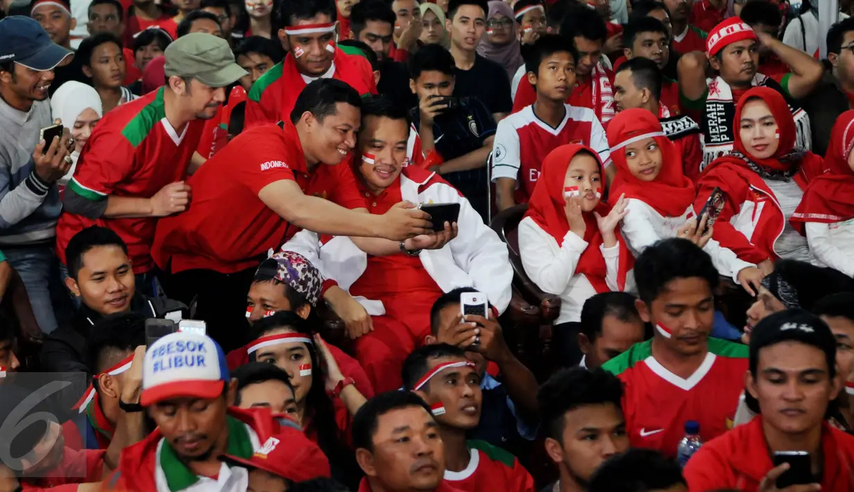 Seorang pendukung berselfie dengan Menpora Imam Nahrawi saat menyaksikan nobar Final Piala AFF 2016 antara Indonesia melawan Thailand di Kemenpora, Jakarta, (17/12). (Liputan6.com/Gempur M Surya)