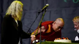Musisi, Patti Smith (kiri) menyaksikan Dalai Lama meniup kue ulang tahun saat acara Glastonbury Festival, Inggirs, (28/6/2015). (REUTERS/Dylan Martinez)