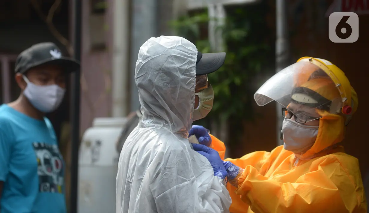 Petugas mengenakan APD bersiap menyemprotkan disinfektan di Pasar Tradisional Cikini dan pemukiman rumah warga  RW 01 Jakarta Pusat, kamis (9/7/2020). Penyemprotan ini untuk mencegah penyebaran virus corona (COVID-19). (merdeka.com/Imam Buhori)