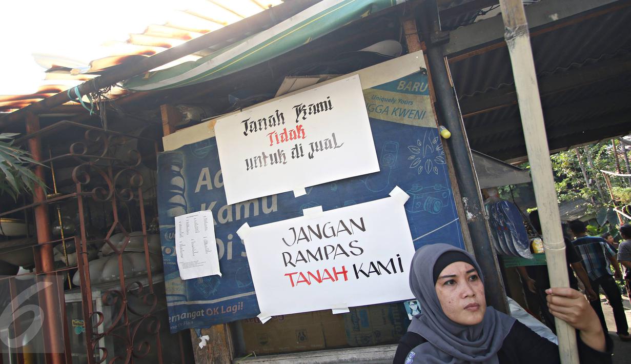 Seorang ibu duduk di dekat poster penolakan penggusuran di Jalan Lauser, RT 08/08, Kebayoran Baru, Jakarta, Senin (9/5). Warga melakukan penjagaan lantaran isu akan ada penyampaian SP-2 terkait penggusuran di lokasi itu. (Liputan6.com/Immanuel Antonius)