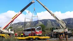 Dua crane dikerahkan untuk mengevakuasi sebuah bus di Jalan Raya AP7 dekat Kota Freginals, Spanyol, Minggu (20/3). Bus berisi 57 penumpang yang mayoritas mahasiswa asing itu terbalik ketika dalam perjalanan dari Valencia menuju Barcelona (PAU Barrena/AFP)