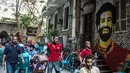 Aktivitas sebuah kedai kopi dengan mural bintang Liverpool, Mohamed Salah yang menghiasi tembok di pusat kota Kairo, 30 April 2018. Mural pemain timnas Mesir tersebut menghiasi sudut negara asalnya. (AFP Photo/KHALED DESOUKI)