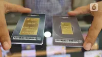 Petugas memperihatkan emas batangan yang dijual di Galeri 24 Pegadaian, Jakarta, Jumat (25/3/2022). Harga emas Antam di Pegadaian kembali naik. Hari ini harga emas Antam naik Rp 6.000 menjadi Rp 1 juta per gram, pada 25 Maret 2022. (Liputan6.com/Angga Yuniar)