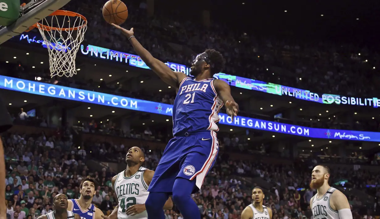 Aksi pemain Sixers, Joel Embiid (21) melakukan lay up melewati pemain Celtics pada game kedua semifinal NBA Wilayah Timur di TD Garden, Boston, (3/5/2018). Boston Celtics menang 108-103. (AP/Elise Amendola)