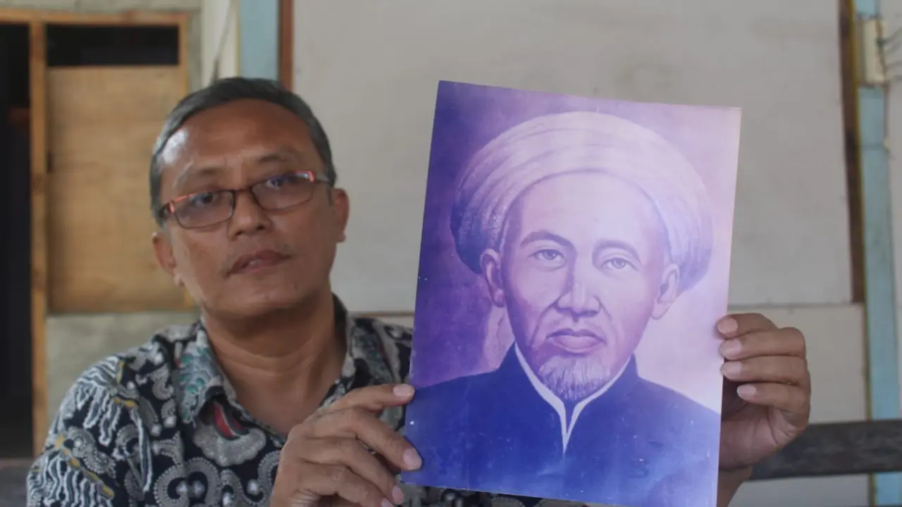 Pengasuh pondok pesantren Al Mustofa, Kiai Mochammad Zainal Arifin saat menunjukkan foto Kiai Hasyim Jalakan (Liputan6.com/Ahmad Adirin)